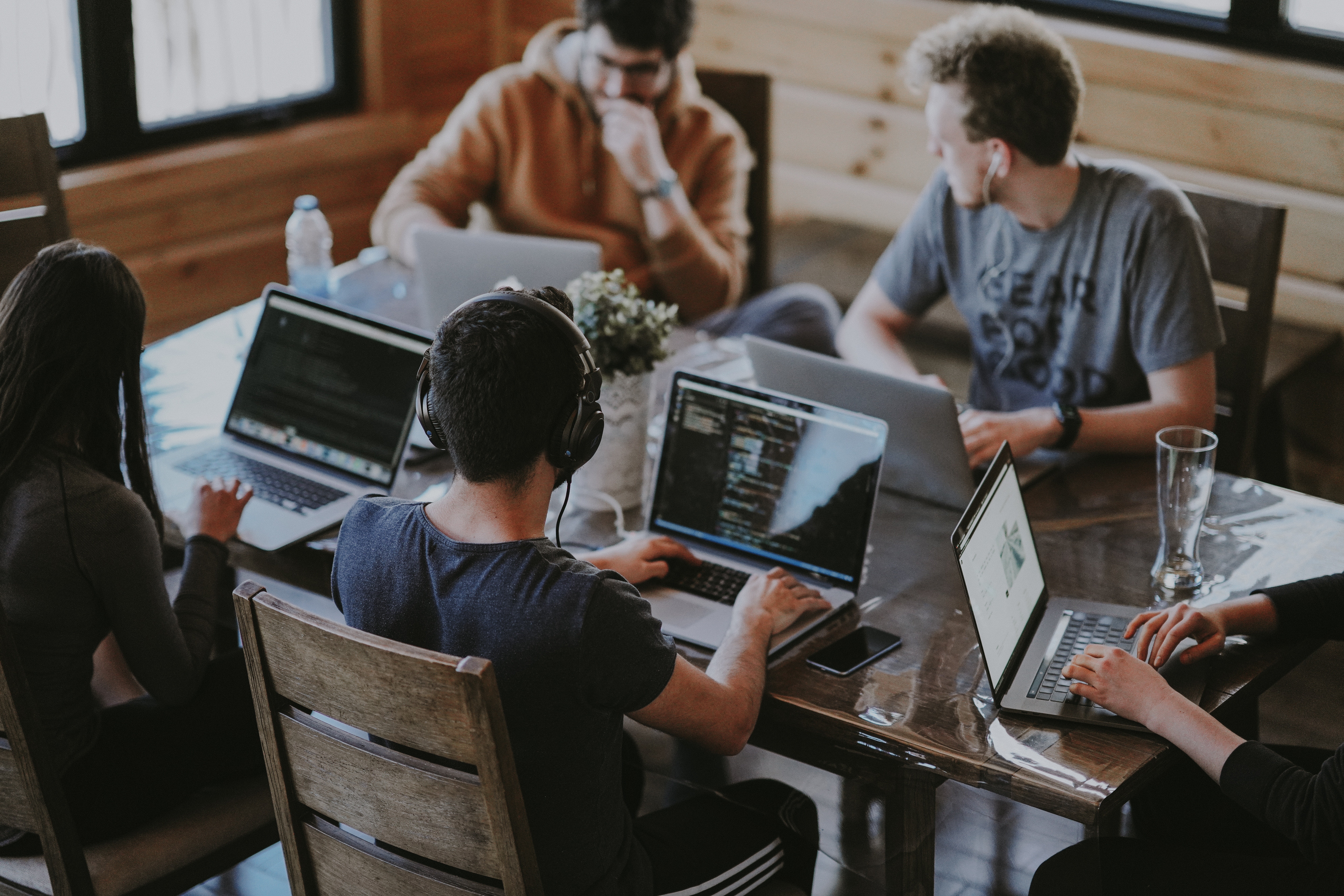 5 people sitting at laptops and networking with each other