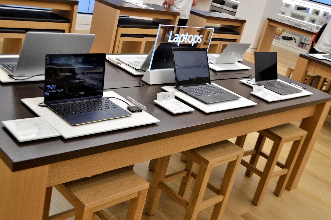 A desk with 6 laptops open